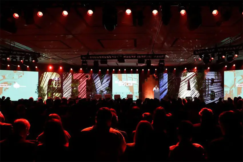 Bloomberg CityLab audience in silhouette watches Clara Brugada speak onstage