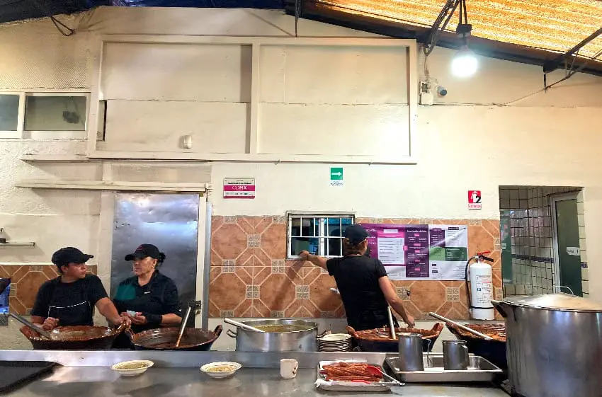 Tres trabajadores de la cocina atendiendo el montaje del buffet de Fonda Margarita