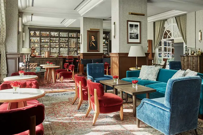 Cafe in Four Seasons Hotel, Mexico City, with velvet upholstered furniture, french doors and cabinets, and worn oriental carpets, creating the feel of a bygone era