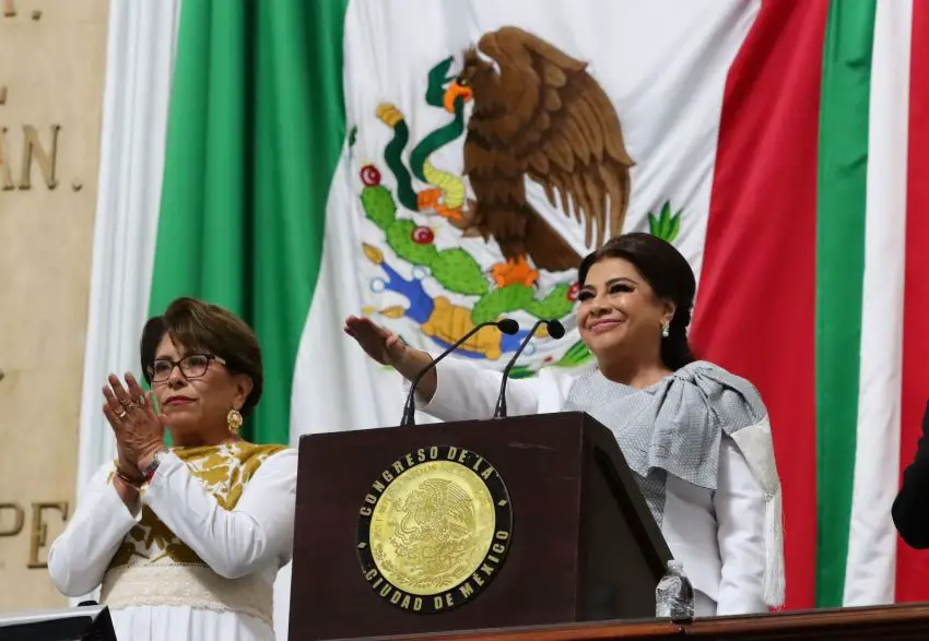 La alcaldesa de la Ciudad de México, Clara Brugada, saluda la bandera al tomar juramento como alcaldesa.