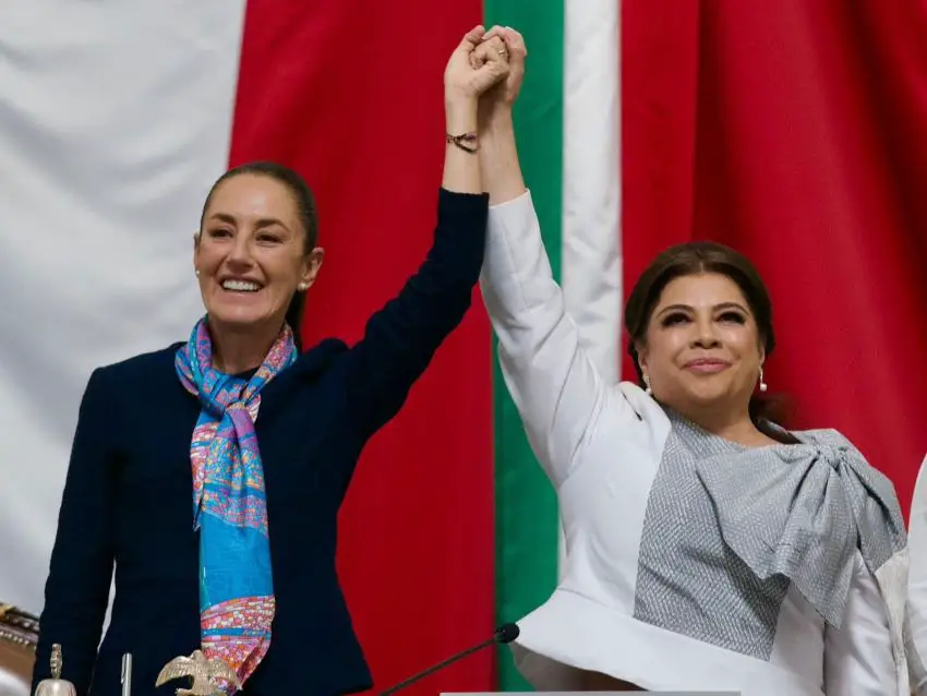 Sheinbaum and Brugada hold their clasped hands in the air at Brugada's swearing-in as Mexico City mayor