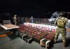 Mexican Navy officials guard the result of their maritime drug bust, with the drugs laid out for a photo