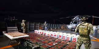Mexican Navy officials guard the result of their maritime drug bust, with the drugs laid out for a photo