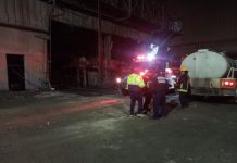 Emergency responders with a water truck at the nighttime scene of an explosion at a Tlaxcala steel mill