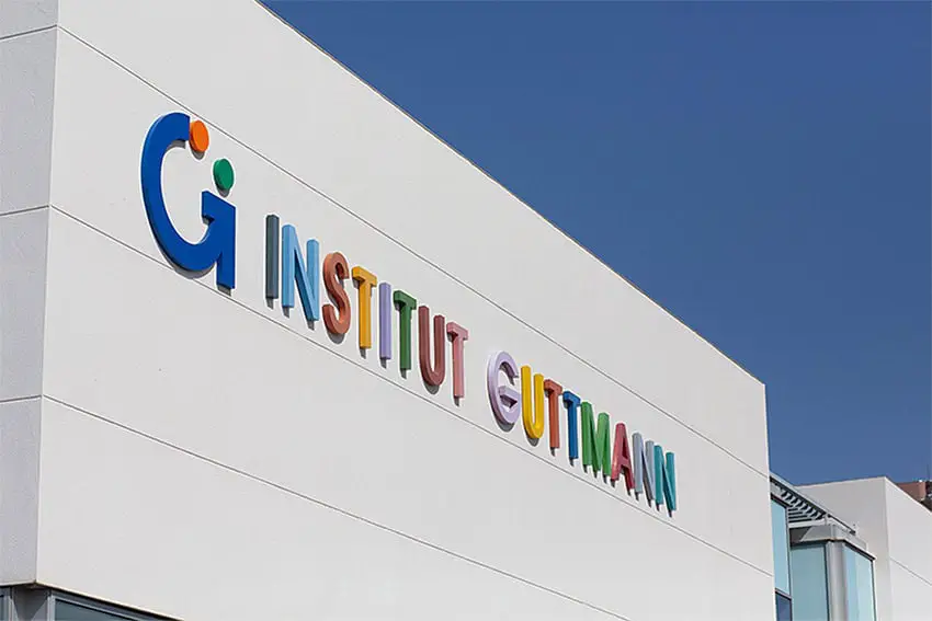 The top of the Institut Guttman building in Barcelona, Spain, featuring its multicolored logo and name.