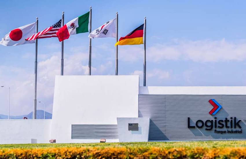 Front wall of Logistik Industrial Park in San Luis Potosi, Mexico. It features the company's name and logo and behind it are flags from Japan, the US, Mexico, and Germany