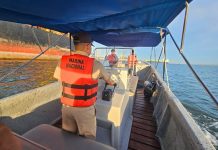 Three members of the Mexican navy in a speedboat on the ocean