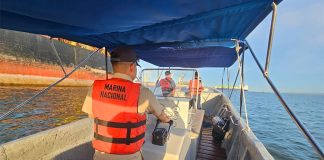Three members of the Mexican navy in a speedboat on the ocean