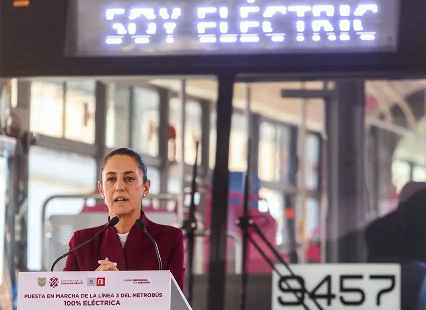 Claudia Sheinbaum as mayor of Mexico City sitting in the driver's seat of a new electric city bus. Above her head, the digital display at the top says "Soy Electric".