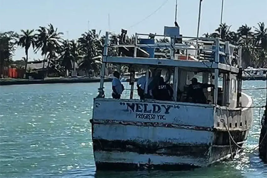 La parte trasera del barco pesquero Neldy moviéndose a través del océano con el chapoteo de una ola golpeando la parte trasera del barco.