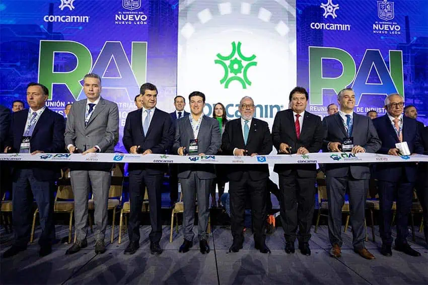 Participants at CONCAMIN's annual industrial manufacturers conference cutting a white ribbon with logos on it to open the event in 2024 in Monterrey, Nuevo Leon in Mexico