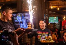 Burger Bar Joint spicy burgers being presented by staff members.