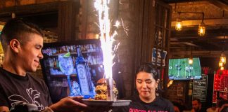 Burger Bar Joint spicy burgers being presented by staff members.