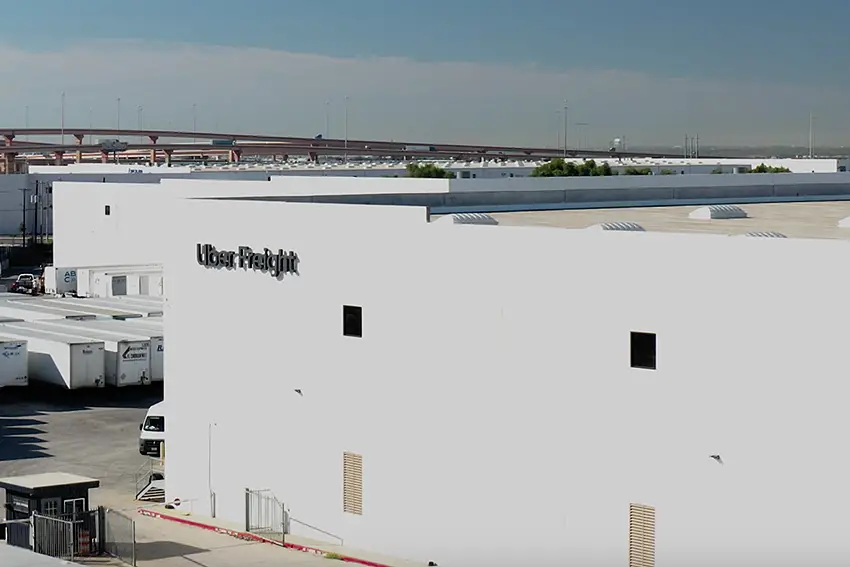 A white Uber freight warehouse in an industrial park in Mexico bearing the company name in the top left corner of the building