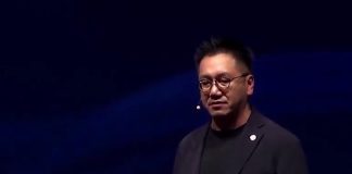 Benjamin Ting, senior vice president at Foxconn on a stage giving a speech wearing a headset microphone.