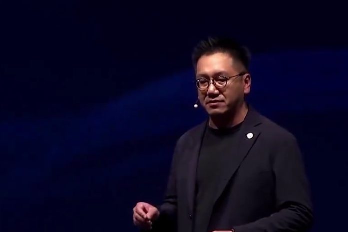 Benjamin Ting, senior vice president at Foxconn on a stage giving a speech wearing a headset microphone.