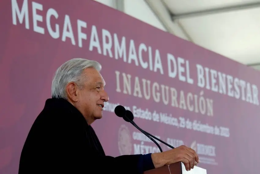 former Mexican president Andres Manuel Lopez Obrador at a podium in front of a giant wall sign saying "Megafarmacia del Bienestar Inauguracion"