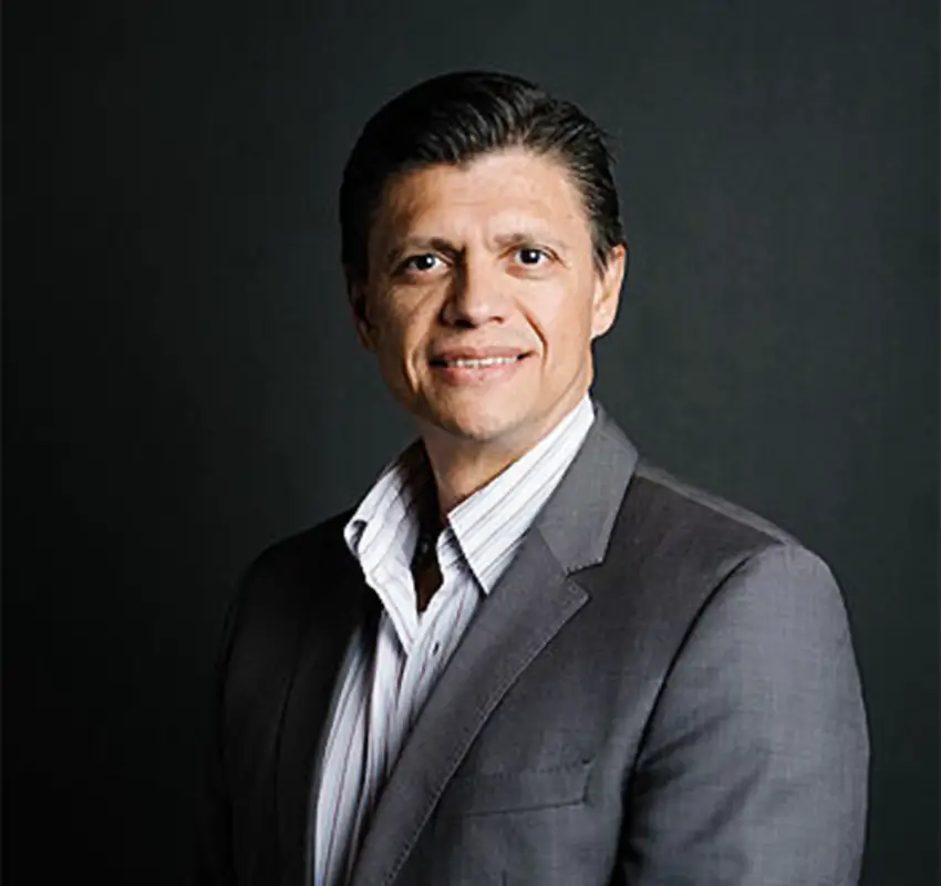 Jesus Ojeda posing for a studio photo in a suit and looking straight at the camera