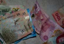 Different Mexican currency bills sitting in a chaotic pile as if thrown on a table