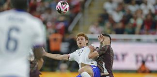 Mexican player disputes a ball with the American opponent.