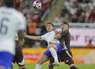 Mexican player disputes a ball with the American opponent.