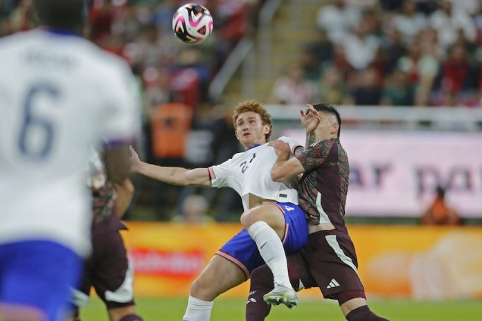 Mexican player disputes a ball with the American opponent.