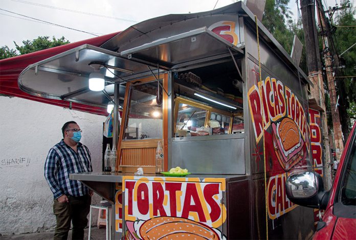 A torta truck with hand-painted signs advertising their product