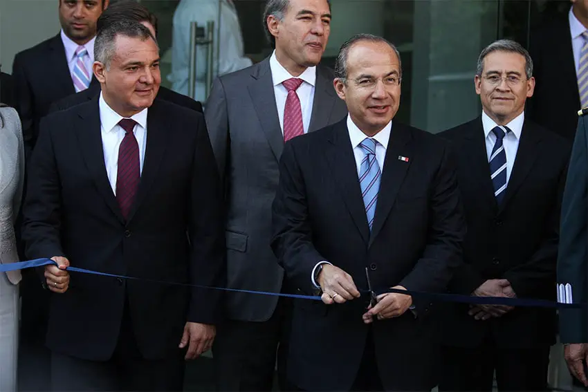 Genaro Garcia Luna standing next to President Felipe Calderon an a ribbon cutting event in 2013.