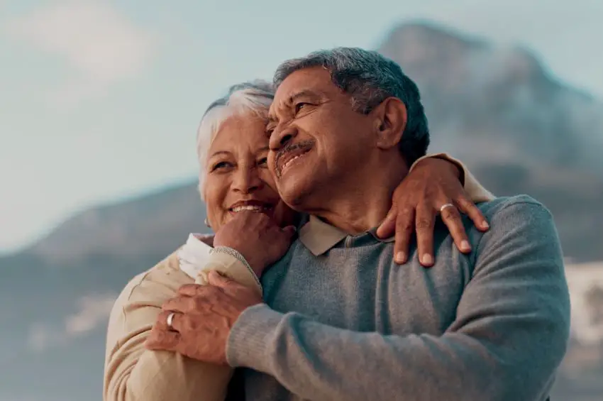 Older couple looking up and hugging in gesture of intimacy