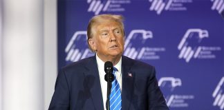 Donald Trump stands at a microphone