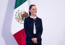 President Claudia Sheinbaum stands with a Mexican flag