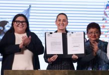 President Claudia Sheinbaum holds up a signed copy of the Mexican women's rights amendment