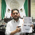 PRI deputy Carlos Eduardo Gutiérrez burns a piece of paper with the names of the INAI and other Mexican watchdog agencies, in Mexico's Senate chambers