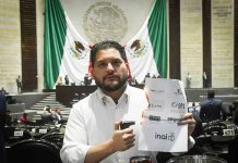 PRI deputy Carlos Eduardo Gutiérrez burns a piece of paper with the names of the INAI and other Mexican watchdog agencies, in Mexico's Senate chambers