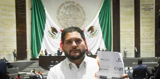 PRI deputy Carlos Eduardo Gutiérrez burns a piece of paper with the names of the INAI and other Mexican watchdog agencies, in Mexico's Senate chambers