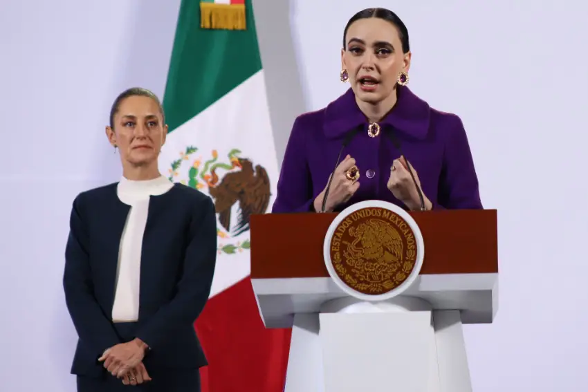 Woman speaking at Mexico's presidential podium as Mexico's President Sheinbaum looks on.