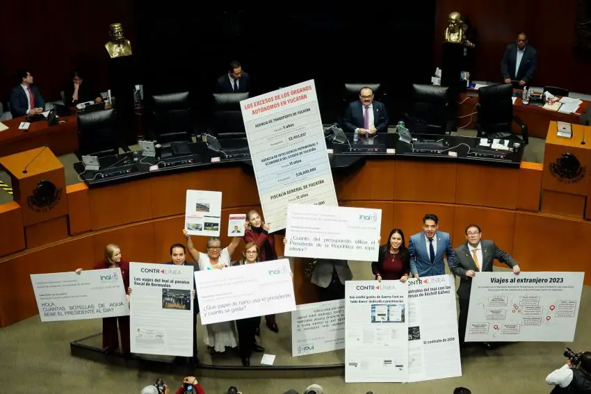 Morena party senators and their allies hold posters showing expenditures of autonomous agencies in the Mexican Senate chambers