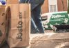 A delivery person from Mexican company Jüsto holds a pair of paper bags