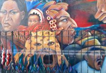 Street mural featuring the larger-than-life heads of Mexican and Mexican indigenous women, as well as a Mexican man wearing a traditional campesino garb, and another man in a jaguar headdress.