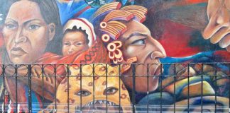 Street mural featuring the larger-than-life heads of Mexican and Mexican indigenous women, as well as a Mexican man wearing a traditional campesino garb, and another man in a jaguar headdress.