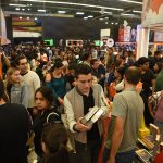 A crowd holds books and moves around a large indoor space at the Guadalajara International Book Fair