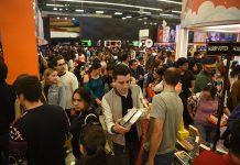 A crowd holds books and moves around a large indoor space at the Guadalajara International Book Fair