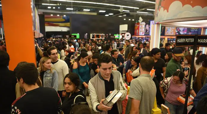 A crowd holds books and moves around a large indoor space at the Guadalajara International Book Fair