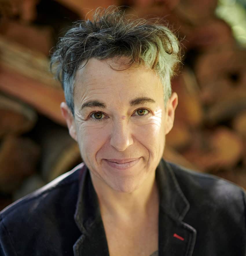 Argentine novelist and Guadalajara International Book Fair prize winner Gabriela Cabezón Cámara, who has short gray hair, looks into the camera for a portrait