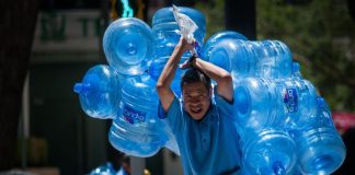 A man carrying a bundle of retornables.