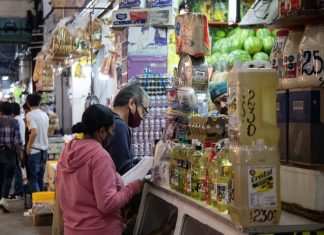 Residents fill their list at a grocery store, at the Central de Abastos, Mexico City.