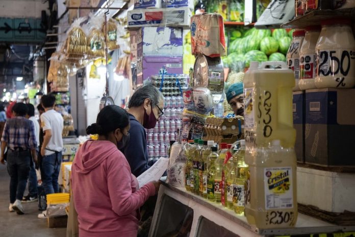 Residents fill their list at a grocery store, at the Central de Abastos, Mexico City.