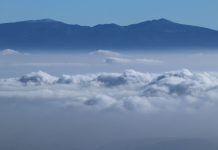 Volcanoes peak through the clouds during a cold front