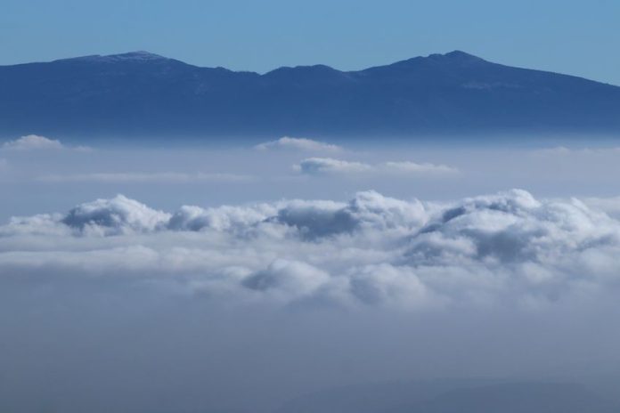 Volcanoes peak through the clouds during a cold front