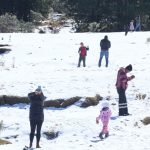 Children and grownups play in the snow in Xalatlaco, México state.